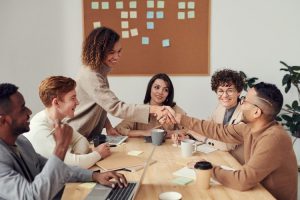 team collega's die elkaar een hand geven met blije gezichten